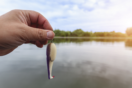 Hand holds a foam lure for catching predatory fishの写真素材