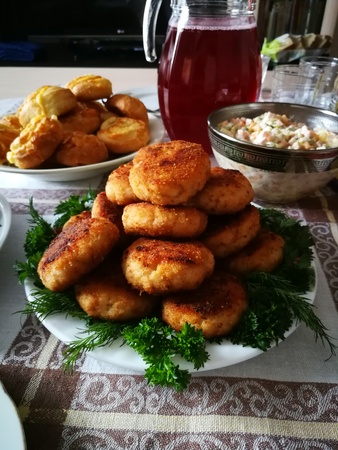 Cutlets lie on a plate on the holiday table.