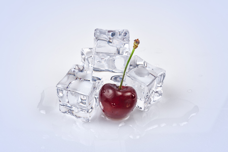 Cherry berry on the background of ice cubes. All on a white backgroundの写真素材