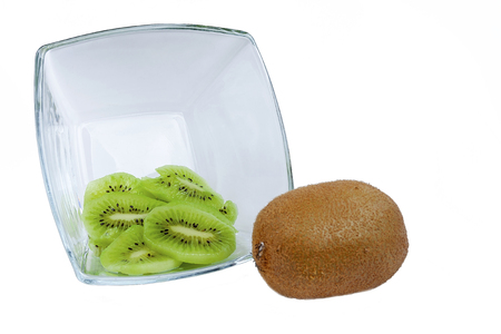 Ripe whole kiwi and peeled kiwi in a glass plate.の写真素材