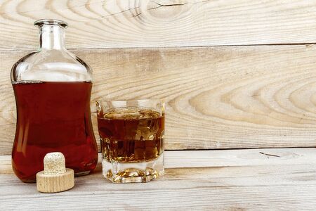 Bottle and glass stand on a wooden table