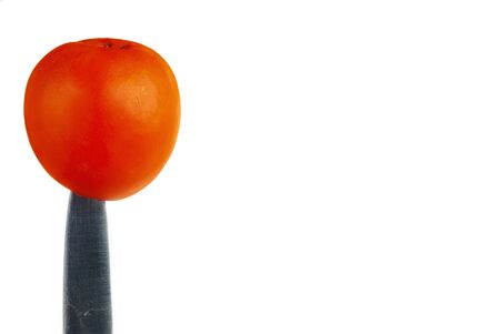 Tomato planted on a knife on a white backgroundの写真素材