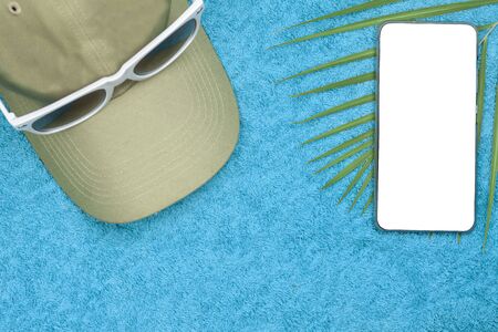 Cap, phone, fern, lie on a towel. The phone has a white background, template