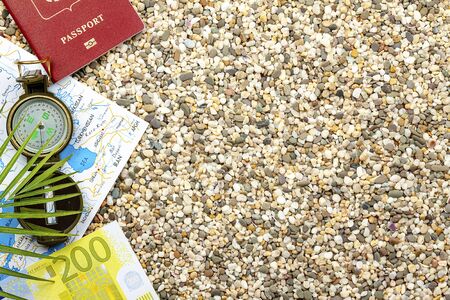 Travel concept, tourism. Compass, map, passport, fern, lie on the sea sand.
