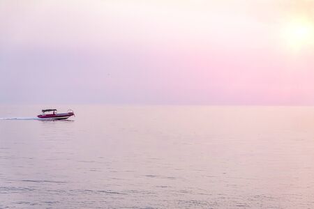 The boat returns to the port in the evening against the setting sunの写真素材