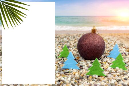 New Year by the sea. New Year's toy on the beach by the sea in the heating of paper Christmas treesの写真素材