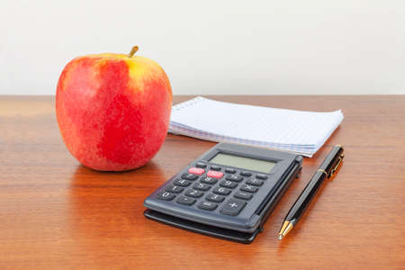Apple pen notepad calculator lie on the table.の写真素材