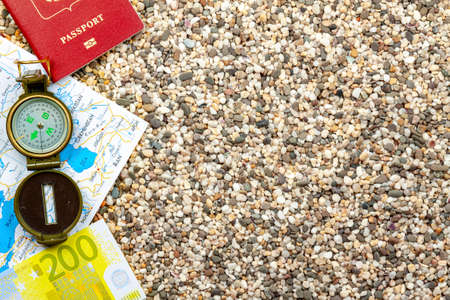 The theme of the journeys. Compass, passport, money, map, lie on a sandy background.の写真素材