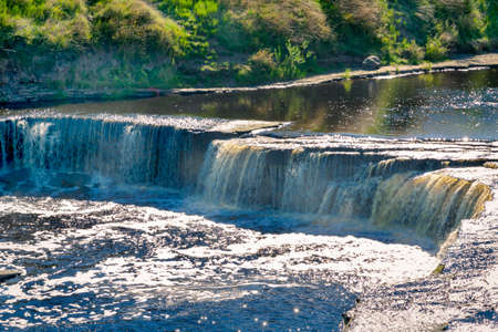 A small waterfall on a small river.の写真素材