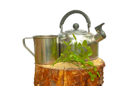 A camping kettle with a mug stands on a wooden stump. All on a white background.の写真素材
