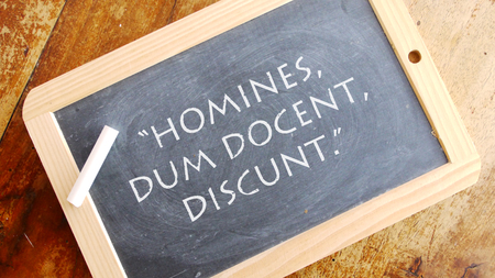 Homines dum docent discunt. A Latin phrase, usually you translated into Inglese as "Men learn while they teach."の写真素材