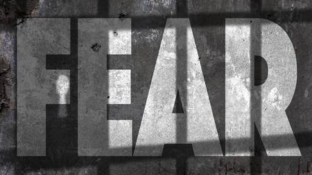 Fear Written On A Wall With Jail Bars Shadowの写真素材