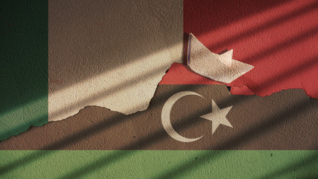 Italy and Libya Flag on Cracked Concrete with Paper Boatの写真素材