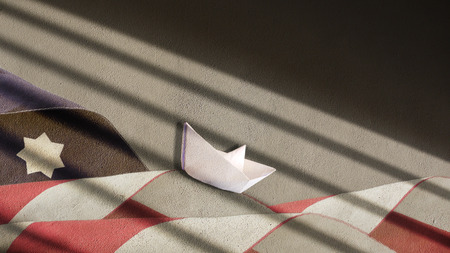 US Flag Waves and Paper Boat on Plaster with Shadowの写真素材