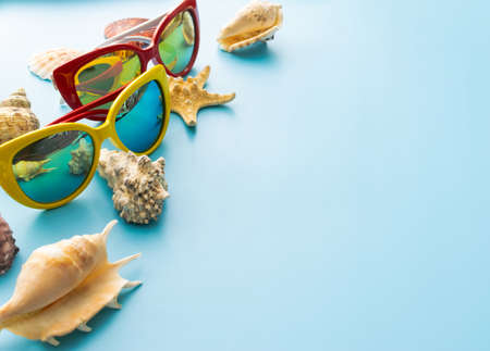 summer background: sunglasses with seashells on blue backgroundの写真素材