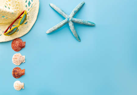 summer background: sunglasses, straw hat, seashells, starfish on a blue backgroundの写真素材