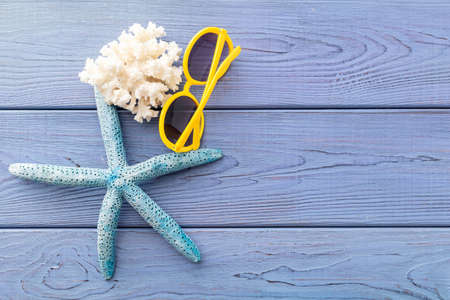 summer background: photo frame, starfish, seashells on a blue wooden backgroundの写真素材