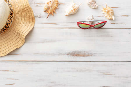summer background: fringed pareos, seashells, sun goggles, starfish on a blue wooden backgroundの写真素材