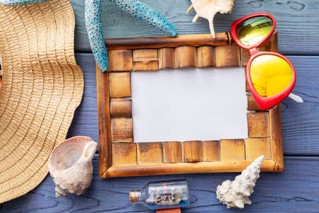 summer background: fringed pareos, seashells, sun goggles, starfish on a blue wooden backgroundの写真素材