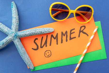 summer background: fringed pareos, seashells, sun goggles, starfish on a blue wooden backgroundの写真素材