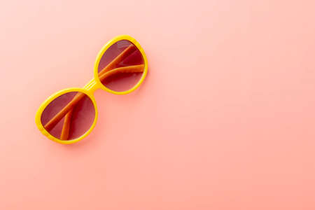 summer background of yellow sunglasses on pink backgroundの写真素材