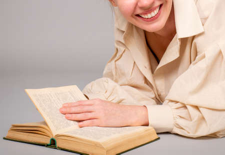woman 40 years old with a book on a light background