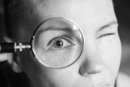 female eye through a magnifying glass close-up