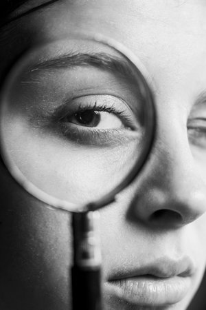 female eye through a magnifying glass close-up