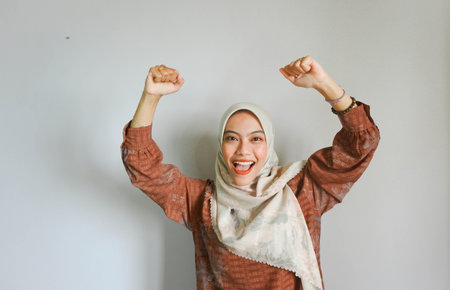 Hijab woman wearing hijab happy and excited celebrating victory with arms raised.の写真素材