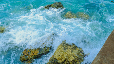 Blue sea with waves and rocks close-up. Nature background.