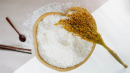 Rice in a wooden bowl and spoon on a white background.の写真素材