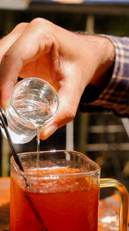 Close-up of a barman pouring liquid sugar from a glass.の写真素材