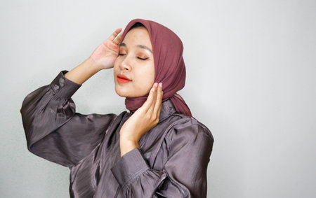 Hijab woman with headache on white background. Health care concept.の写真素材
