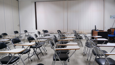 Empty classroom with rows of chairs and desks in a lecture hall.の写真素材
