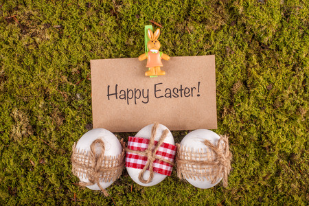 Happy Easter card and eggs on green moss background. Easter handmade decoration