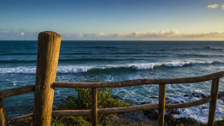Beautiful view of the Pacific Ocean from a wooden fence at sunsetの写真素材