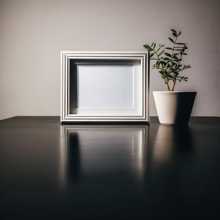 White photo frame on the black table with plant in vase.