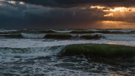 Sunset over the sea with stormy clouds and sunbeams