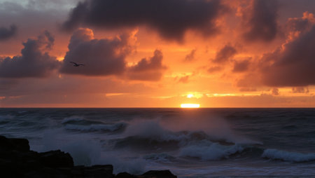Sunset over the sea with waves crashing against the rocks and cliffsの写真素材