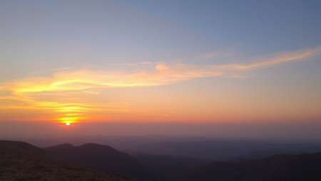 Sunset at the top of the mountain with a view of the valleyの写真素材
