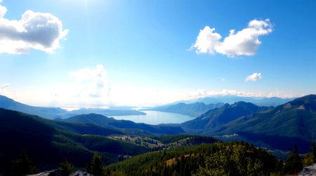 panoramic view of the lake and mountains on a sunny dayの写真素材
