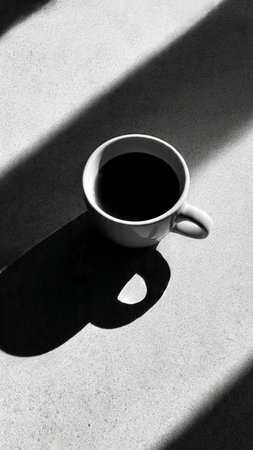 Cup of coffee with shadow on the floor. Black and white.の写真素材