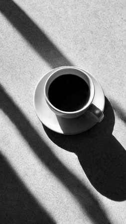 Cup of coffee with shadow on the floor. Black and white.の写真素材