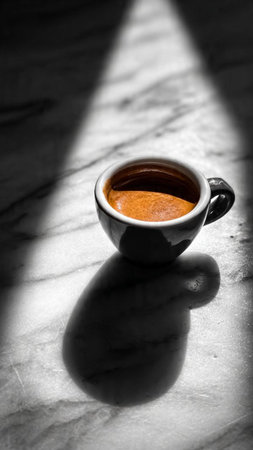 Cup of coffee with shadowle surface. Black and white photo.の写真素材