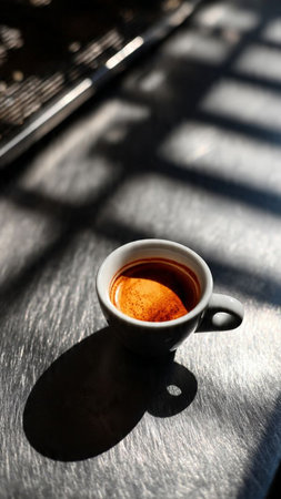 Cup of coffee on the table with shadow on the wall.の写真素材