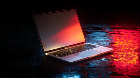 Laptop on wet asphalt illuminated by red light. 3D rendering.の写真素材