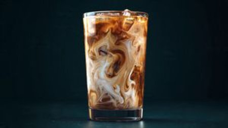 Iced coffee in a glass on a dark background. Close-up.