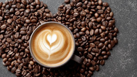 Cup of coffee with latte art and coffee beans on grey background