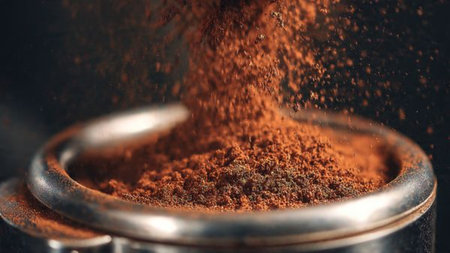 Coffee pouring into a filter on a dark background closeup