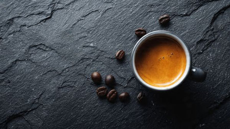 Coffee cup and coffee beans on black stone background, top view